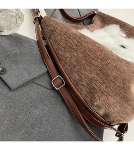 Détail de la ferronnerie argentée et du tissu en velours côtelé marron sur le sac chien