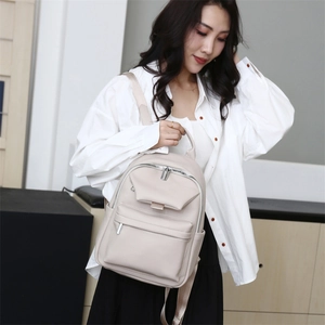 Detailed view of beige pebble grain faux leather backpack with adjustable straps for women