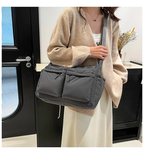 Détail du grand sac bandoulière en nylon gris foncé avec poches zippées multiples