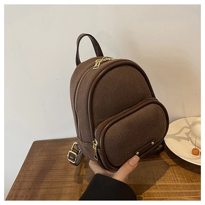 Détail du mini sac à dos vintage montrant la texture toile et les zips dorés brillants