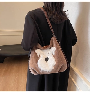 Détail du sac fourre-tout en velours marron avec applique de chien en peluche et bandoulière