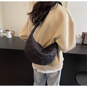 Détail du sac croissant en nylon matelassé noir avec une large bandoulière réglable