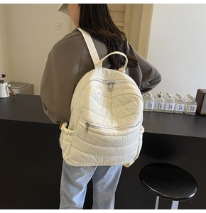 Detail of soft quilted puffer backpack in cream white with premium stitching texture