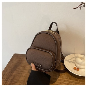Détail d'un mini sac à dos vintage en laine marron avec bordure en cuir et métal doré