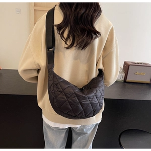 Détail du sac croissant matelassé en nylon noir avec bandoulière réglable en toile