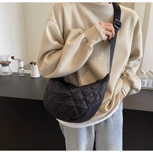 Vue détaillée du sac bandoulière matelassé noir en forme de croissant avec sangle réglable