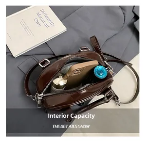 Internal capacity of the brown glossy leather bag showing phone and cosmetics storage