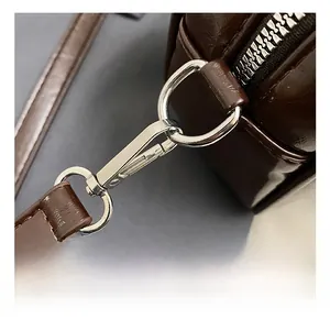 Detail of premium brown PU leather bag with shiny silver metal hook and sleek stitching
