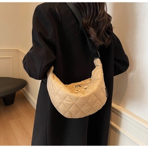 Détail du sac croissant en nylon beige matelassé avec bandoulière réglable et coutures