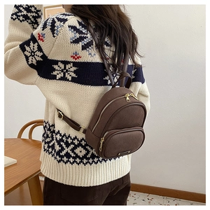 Détail d'un mini sac à dos vintage marron avec texture suédée et fermetures éclair dorées