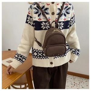 Gros plan détaillé d'un mini sac à dos vintage marron foncé avec fermetures éclair dorées