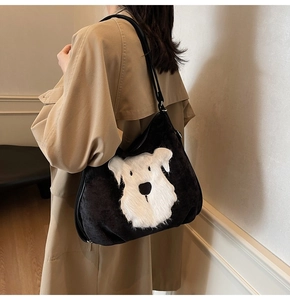Détail d'un cabas en velours noir avec écusson chien blanc porté par un mannequin