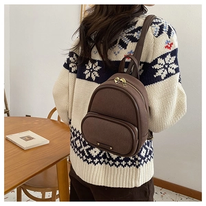 Détails du mini sac à dos marron en laine avec fermetures éclair dorées sur un mannequin