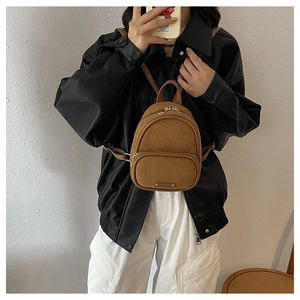 Détail d'un mini sac à dos vintage en cuir mat marron avec fermetures dorées