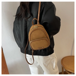 Mini sac à dos marron en daim synthétique porté en bandoulière par un mannequin de dos