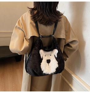 Détail du sac cabas en peluche noire douce avec une broderie de chien de dessin animé blanc
