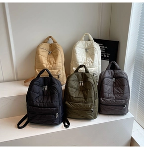 Macro shot of quilted backpack variety in black, white, khaki, green and grey finishes