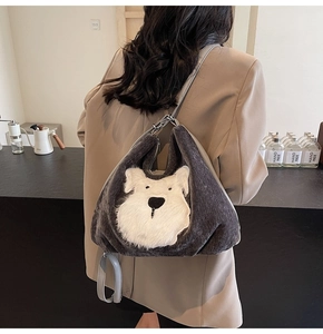 Détail du sac cabas en peluche grise avec un motif de chiot en 3D porté par un mannequin