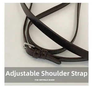 Detail view of dark brown adjustable leather shoulder strap with silver buckle