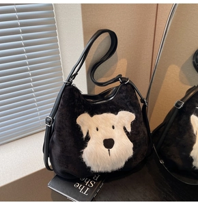 Vue détaillée d'un sac cabas en velours noir avec un écusson en peluche de schnauzer blanc