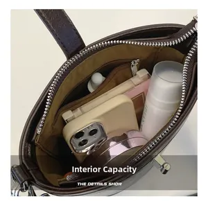 Top view of spacious internal capacity with inner zipper pocket in brown leather bucket bag
