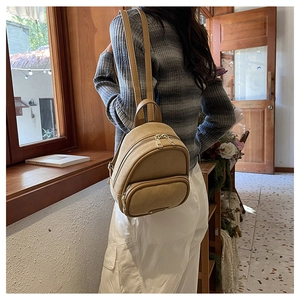 Détail d'un mini sac à dos rétro kaki avec bretelles réglables dans un décor vintage