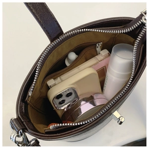 Interior view of leather bucket bag showing storage space for phone and makeup