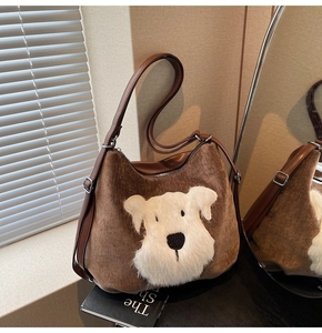 Détail macro du sac cabas en velours marron avec écusson chien peluche et bandoulière