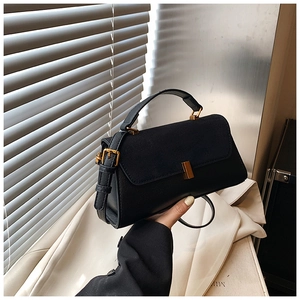 Détail du sac à main noir avec boucle dorée et bandoulière réglable amovible