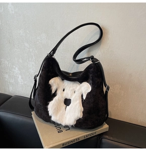 Gros plan du patch de chiot schnauzer sur un sac fourre-tout noir en velours et cuir