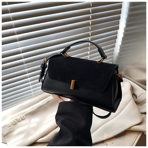 Détail du sac bandoulière noir en cuir et suède avec boucle métallique dorée