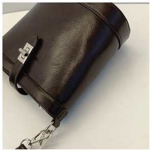 Close-up of brown bucket bag showing glossy lychee texture and silver metal hardware