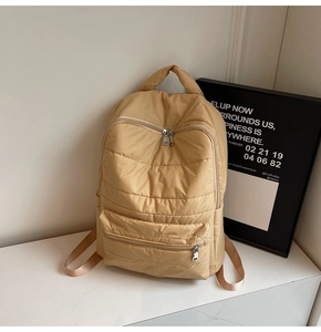 Nahaufnahme des gesteppten Puffer-Rucksacks in Khaki mit silbernem Reißverschluss