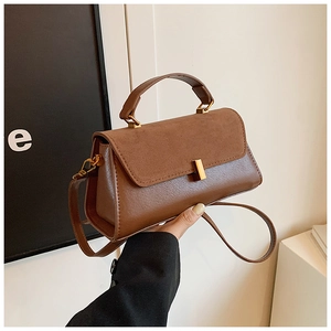 Détails du sac à main marron en patchwork avec fermoir doré et texture en daim doux