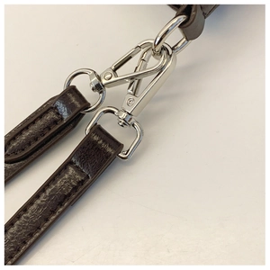 Detail of dark brown lychee texture leather straps with silver lobster clasps and D-rings