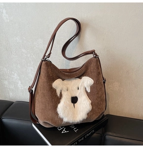 Détail du cabas en velours côtelé marron avec écusson chiot peluche et sangle en cuir