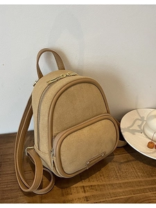 Mini sac à dos vintage kaki en toile et cuir sur une table en bois pour style décontracté