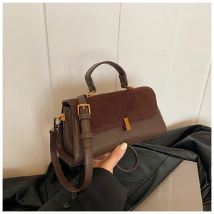 Gros plan d'un sac à main vintage marron avec fermoir doré et texture en daim