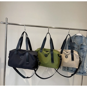 Three colors of waterproof travel bags hanging with handles and adjustable shoulder straps
