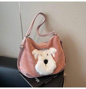 Détail du cabas en velours rose avec écusson chiot en peluche blanche et sangle