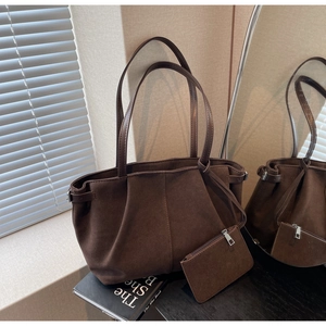 Detail einer dunkelbraunen Wildleder-Tragetasche mit Faltendesign und kleiner Tasche