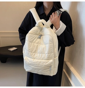 Detailansicht der Seitenprofils für den cremeweißen gesteppten Daunenrucksack mit Trägern