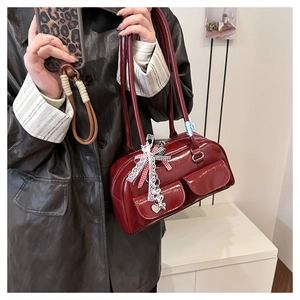 Detail der weinroten Lackleder-Bostontasche mit Schleifen und Herz-Anhängern