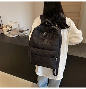 Detailansicht des schwarzen Stepprucksacks mit mehreren Reißverschlüssen und Nylonstruktur