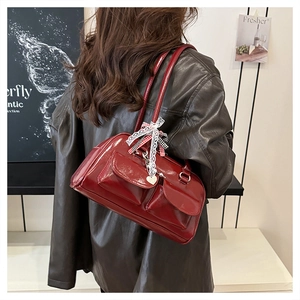 Detail der dunkelroten Vintage-Schultertasche mit Vordertaschen und Spitzenbogen