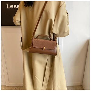 Detail of a brown vintage leather handbag showing the gold metal clasp and stitching