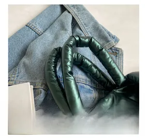 Detail van de comfortabele metallic groene gewatteerde handgreep van een draagtas