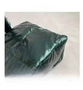 Detailopname van gewatteerde donkergroene metallic stof met een glanzende coating