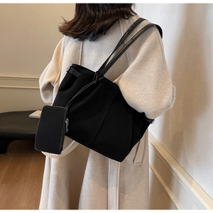 Detail eines schwarzen Shopper-Sets mit kleinem Reißverschlussbeutel am Modell
