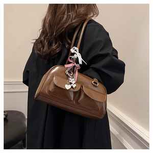 Details der braunen Bowling-Tasche mit zwei Taschen und Herz-Anhängern im Retro-Look